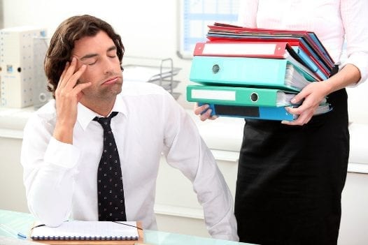 Employees Regularly Exaggerate Work Hours tired employee image