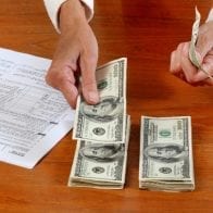 Identity Theft, Tax Fraud Increase as IRS Attempts to Curb Crimes Counting bills next to tax form
