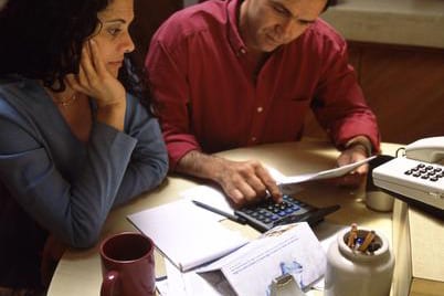 5 Financial Stats You Need to Know to be Successful with Money Woman and man working on calculator