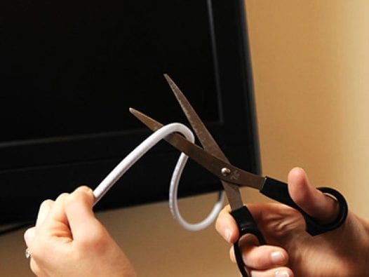 Frugal Man Pulls Plug on Cable, Saves $1,200 a Year Scissors cutting cable cord from television