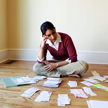 Woman looking at bills on the floor