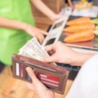 Want To Reduce Credit Card Debt? Only Pay With Cash Man buying with cash instead of a credit card