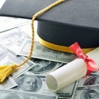 Should You Use Annuity Cash to Pay Off Student Loans? Graduation cap on stack of money