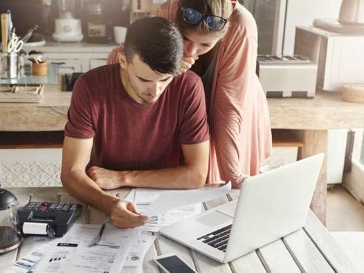 How to Pay off Holiday Debt Fast: 5 Strategies Woman and man stressing over holiday bills