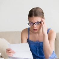 Debt Consolidation or Bankruptcy? Which is Better? woman stressed about bills