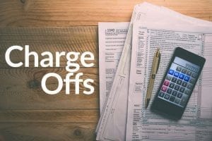 Paperwork for Charge offs on table with calculator