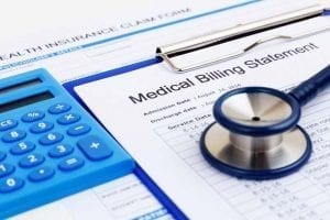 Medical bill with stethoscope on calculator 