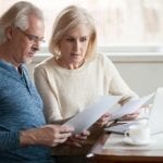 Older couple sitting with papers and considering bankruptcy
