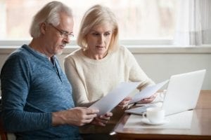 Older couple sitting with papers and considering bankruptcy