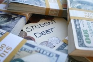 Money on a table with Student Debt written on a paper