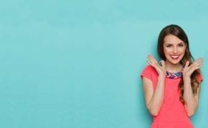 Young women happy standing in front of a light blue background