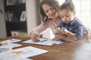 Mom and daughter coloring on a table