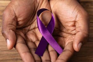 Hands holding ribbon for Alheimers awareness