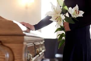 Hand placed on casket at a funeral