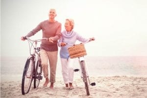 Senior citizens with bikes on the beach
