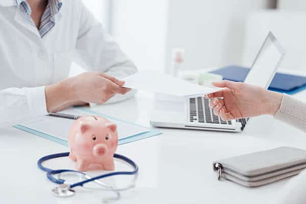 Doctor handing medical loan financing agreement to patient