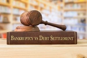 Law book titled "Bankruptcy vs Debt Settlement"