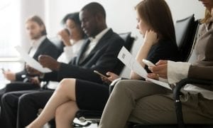 Multi ethnic group sitting in lobby keeping to themselves awaiting job interview