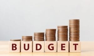 Coins on stack stair as step growing growth and wooden cube block with word BUDGET