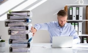 Businessperson pushing paper documents away and working with digital documents on computer instead