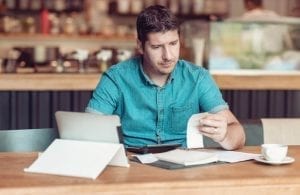 Businessman looking overwhelmed while going over taxes