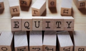 the word "equity" spelled out with toy wooden blocks on table