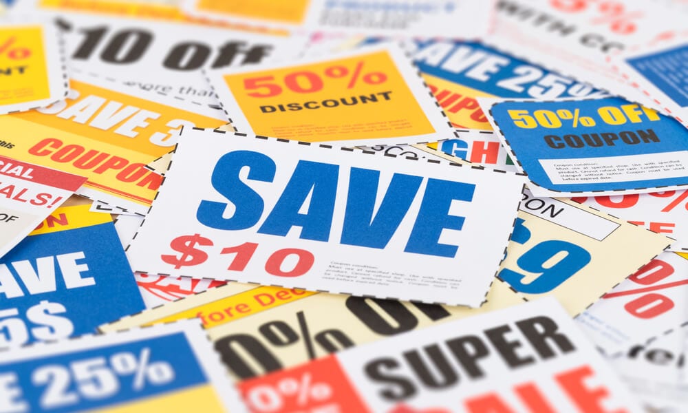 Photo of coupons piled on top of each other that say "sale" and "save"