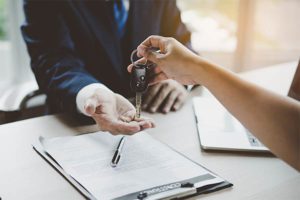 Dealer handing new car keys to the buyer who recently filed bankruptcy