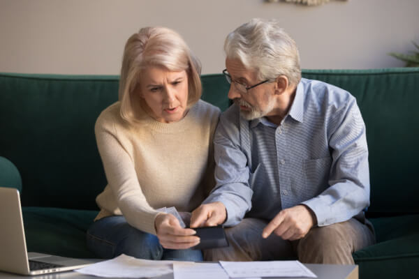 Elderly couple discussing how to pay their credit card debt on a fixed income