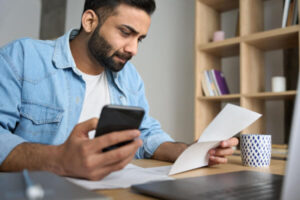 Young man researching ways to borrow money on his phone