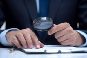 Bankruptcy trustee investigating a document with a magnifying glass