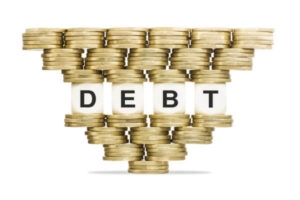 Coins stacked on top of cubes spelling out debt