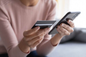 Woman paying her car payment with a credit card using her phone