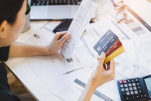 Woman looking at many credit cards in her hand and worried about loan debt pay late.