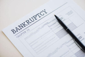 High angle view of pen on document with bankruptcy and chapter 13 lettering on white.