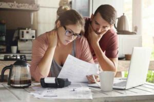 Woman and man studying paper together in kitchen representing consolidation loan options.