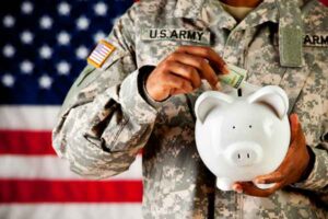 Soldier putting money in piggy bank representing military banks and credit unions.