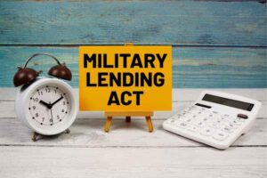 Military Lending Act text written on paper card with calculator and alarm clock on wooden background